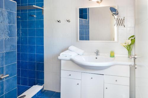 een badkamer met een wastafel, een spiegel en een douche bij Garden Apartments in Rózia
