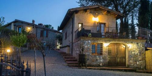 une grande maison en pierre avec des lumières sur son côté dans l'établissement Podere Vigna del Sole, à San Gimignano