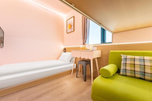 a living room with a green couch and a table at Lemon Hotel - Metro Line 1 Line 7 Changshu Road 200 meters in Shanghai