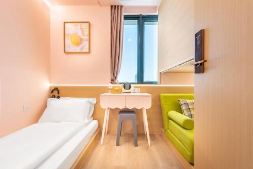 上海市にあるLemon Hotel - Metro Line 1 Line 7 Changshu Road 200 metersのベッドとテーブル付きの小さな部屋