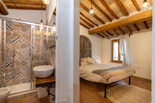 Schlafzimmer mit einem Bett, einer Badewanne und einem Waschbecken in der Unterkunft Casa Vesta in San Gimignano