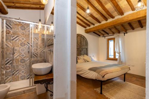 een slaapkamer met een bed, een bad en een wastafel bij Casa Vesta in San Gimignano