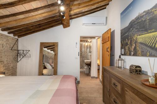een slaapkamer met witte muren en houten plafonds bij Casa Vesta in San Gimignano