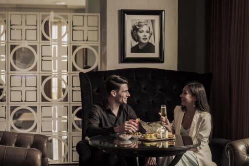 a man and a woman sitting at a table at Four Seasons Hotel Abu Dhabi at Al Maryah Island in Abu Dhabi