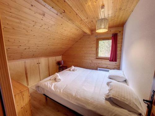 a bedroom with a bed in a wooden cabin at Le chalet des Broches - jacuzzi in Xonrupt-Longemer