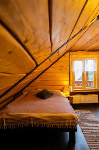 a bed in a wooden room with a window at Ранчо Скарбова Гора in Selisko