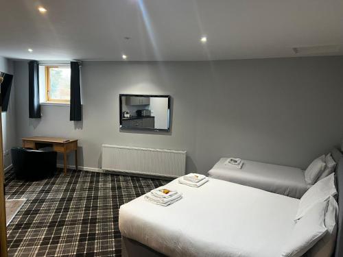 a hotel room with two beds and a mirror at Crown Hotel & Bar in Inverness