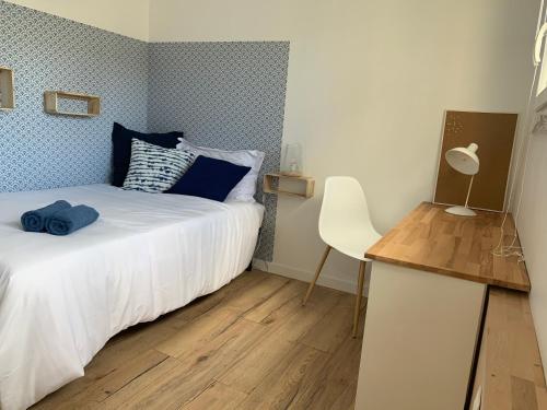 une chambre avec un lit, une table et une chaise dans l'établissement Appartement Cosy, proche Paris, parking gratuit, à Pontoise
