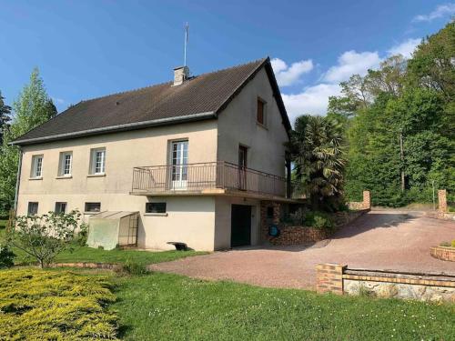 a large white house with a balcony and a driveway at Maison de campagne proche de Sézanne avec parking in Le Meix-Saint-Époing