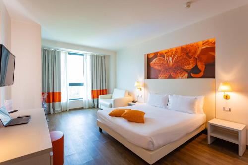 a hotel room with a bed and a desk at ibis Styles Milano Est Settala in Settala