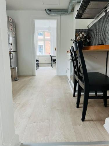 a dining room with a table and black chairs at Lovely 1-bedroom condo in Aarhus C in Aarhus