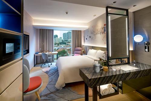 Habitación de hotel con cama grande y TV en Capri by Fraser China Square, Singapore en Singapur