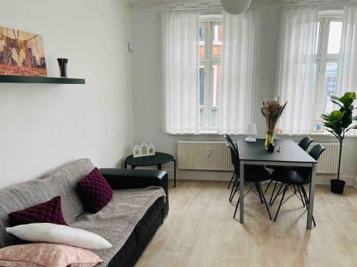 ein Wohnzimmer mit einem Sofa und einem Tisch in der Unterkunft Lovely 1-bedroom condo in Aarhus C in Arhus