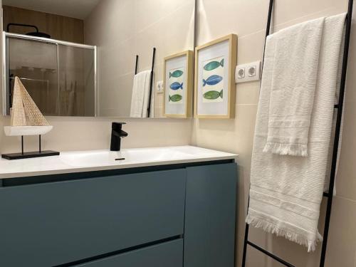 a bathroom with a sink and a mirror and towels at Beautiful apartment on the Costa Brava · Can Bosch in Sant Feliu de Guixols