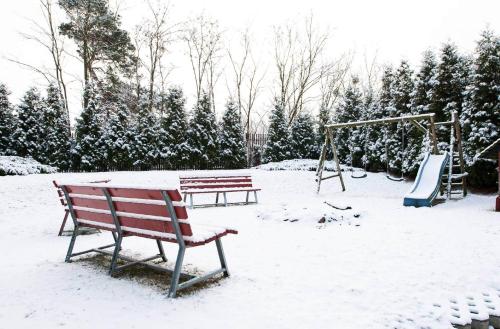 two benches in a park covered in snow at Ośrodek Wypoczynkowy TVP in Ciechocinek