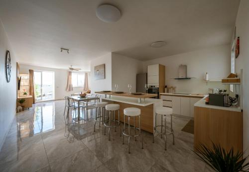 a kitchen with a counter and stools in it at Amazing terraced apartment with free parking in Marsaskala
