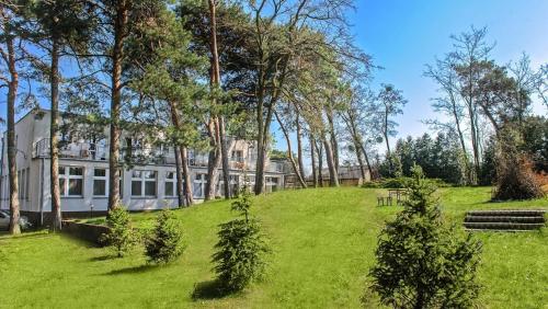 a house on a hill with trees and green grass at Ośrodek Wypoczynkowy TVP in Ciechocinek