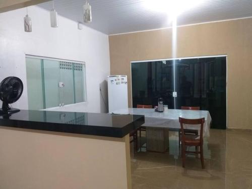 a kitchen with a counter and a table and chairs at Casa confortável e bem localizada in Macapá