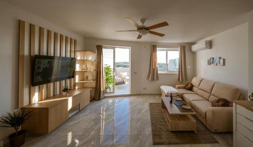 a living room with a couch and a tv at Amazing terraced apartment with free parking in Marsaskala