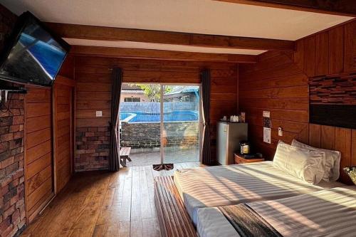 a bedroom with a bed and a sliding glass door at Ozone Resort & Pool Villa in Phatthalung