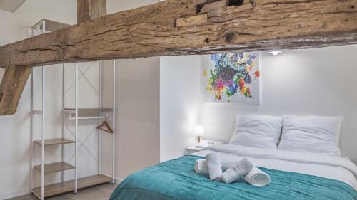 une chambre avec un lit avec deux serviettes dessus dans l'établissement Le Repaire des Templiers - 6 pers. - Cour Calme, à Troyes