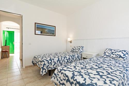 卡门港Guasimeta Duplex - Pool & Balcony的一间有两张床和走廊的酒店房间