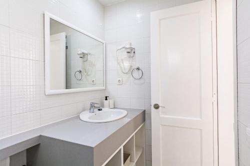 卡门港Guasimeta Duplex - Pool & Balcony的一间白色浴室，配有洗手池和镜子。