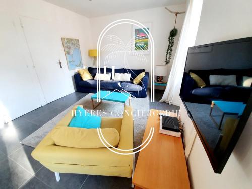 ein Wohnzimmer mit einem gelben Sofa und einem Tisch in der Unterkunft Petit Moulin-T3 Giens-Clim-Parking in Hyères