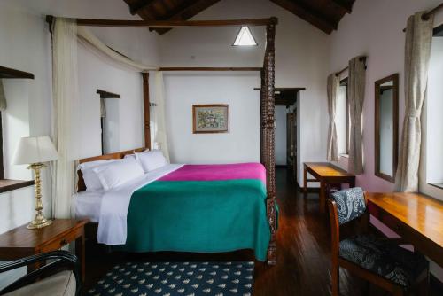 a bedroom with a bed and a desk and a chair at Tiger Mountain Pokhara Lodge in Pokhara