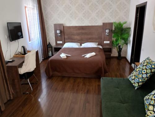 a bedroom with a bed with two towels on it at Two Lions Hotel in Tbilisi City