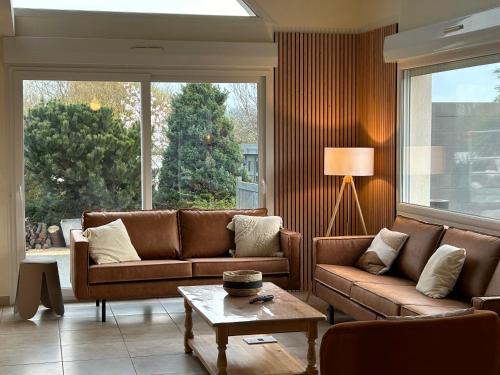 uma sala de estar com dois sofás e uma mesa em Le Wim'Heureux Campagne em Bazinghen