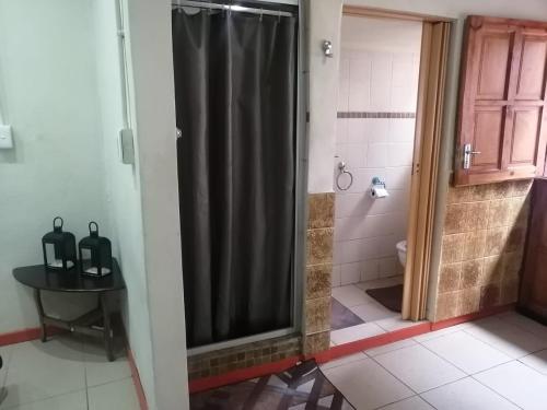 eine Dusche mit einem schwarzen Duschvorhang im Bad in der Unterkunft Limelight in Polokwane