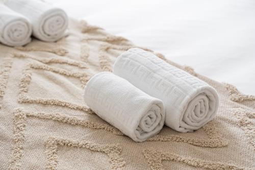 stos białych ręczników siedzących na ręczniku w obiekcie GuestReady - A lovely vacation in Matosinhos w mieście Matosinhos