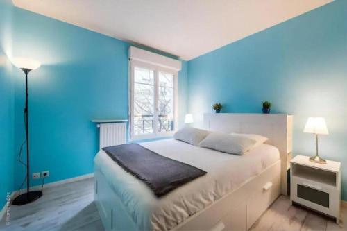 une chambre bleue avec un lit et une fenêtre dans l'établissement S10 Disney Shopping Center, à Serris