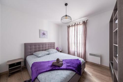 Un dormitorio con una cama con un osito de peluche en una manta púrpura en S4 Disney Family en Serris