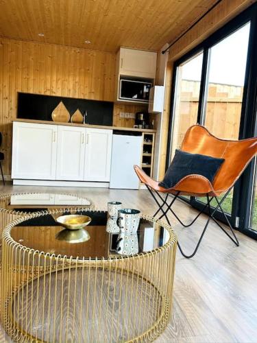 un salon avec une table et une chaise dans l'établissement Le Nid douillet proche de la mer. La clef des paons, à Luc-sur-Mer