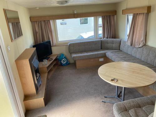 a living room with a couch and a table at Dog Friendly Caravan Near To Heacham Beach, Ref 21011c in Heacham