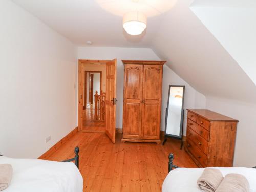 a bedroom with two beds and a wooden dresser at The Skating Rock in Banane Bridge