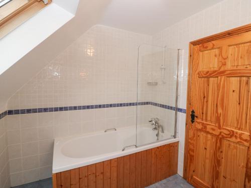 a bathroom with a bath tub with a glass door at The Skating Rock in Banane Bridge