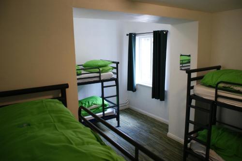 a room with three bunk beds and a window at YHA Helvellyn in Glenridding