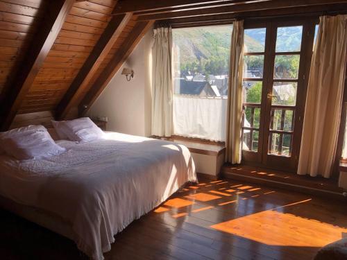 a bedroom with a bed and a large window at CASA ARTÍES in Arties
