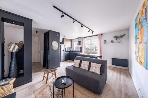 ein Wohnzimmer mit einem Sofa und einer Küche in der Unterkunft Appartement Proche Disney Paris Vidéo-Projecteur in Bussy-Saint-Georges