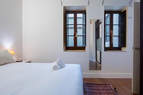1 dormitorio con 2 camas y 2 ventanas en Plaza San Marcos Apartment, en Sevilla