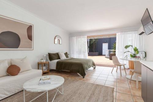 a white living room with a bed and a couch at The Lane - Byron Bay in Byron Bay