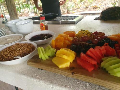 une planche à découper avec des fruits et des légumes sur une table dans l'établissement Paradise River Lodge, à Hoedspruit