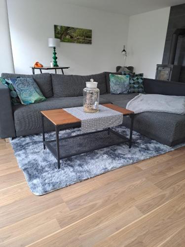 ein Wohnzimmer mit einem Sofa und einem Tisch in der Unterkunft Ferienwohnung Waldeule in Bad Kissingen