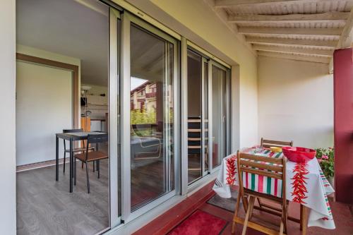 d'un balcon avec des portes coulissantes en verre et une table. dans l'établissement Charmant studio proche des plages d'Anglet, à Anglet