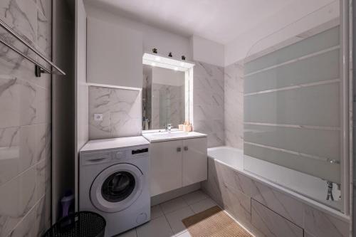 a bathroom with a washing machine and a sink at Disney Skyline Suite in Bussy-Saint-Georges