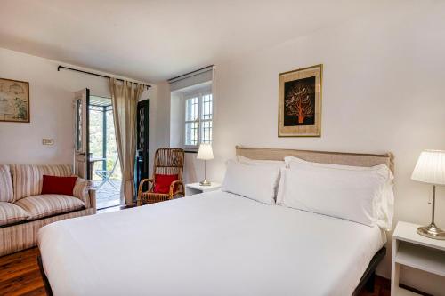 una camera con un grande letto bianco e un divano di Villa Rica by Wonderful Italy a Santa Margherita Ligure