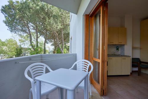 een kleine witte tafel en 2 stoelen op een balkon bij Residence Piccolo in Milano Marittima